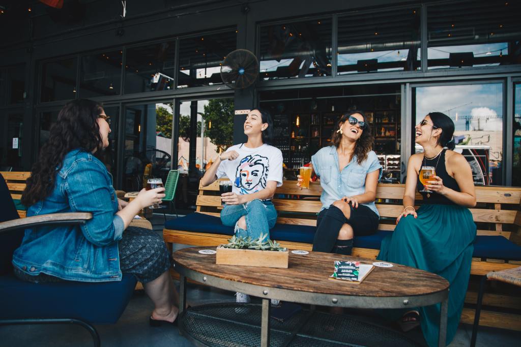 Vier Frauen unterhalten sich, während sie auf einer Bank sitzen