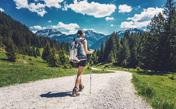 Preocupaciones sobre el cambio climático mientras una dama camina en un hermoso paisaje montañoso