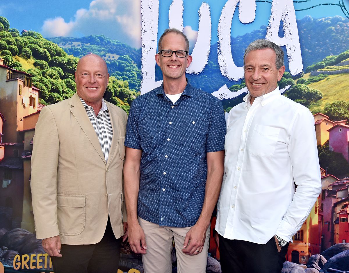 Bob Chapek, Pete Docter, and Bob Iger pictured standing in front of art and logo for the Pixar film Luca