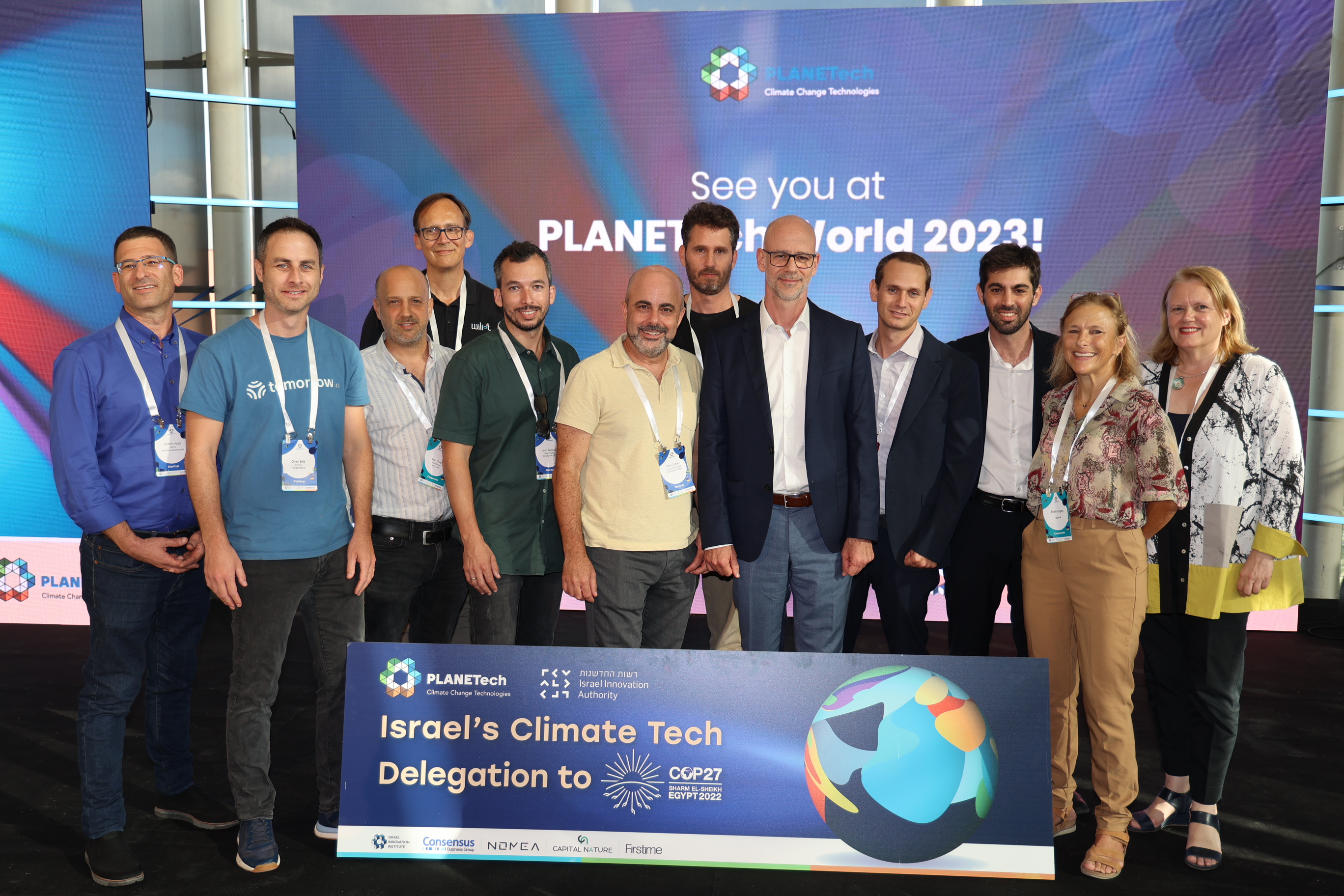 Multiple men and two women posing behind a sign labeling them as Israel's Climate Tech Delegation to COP27
