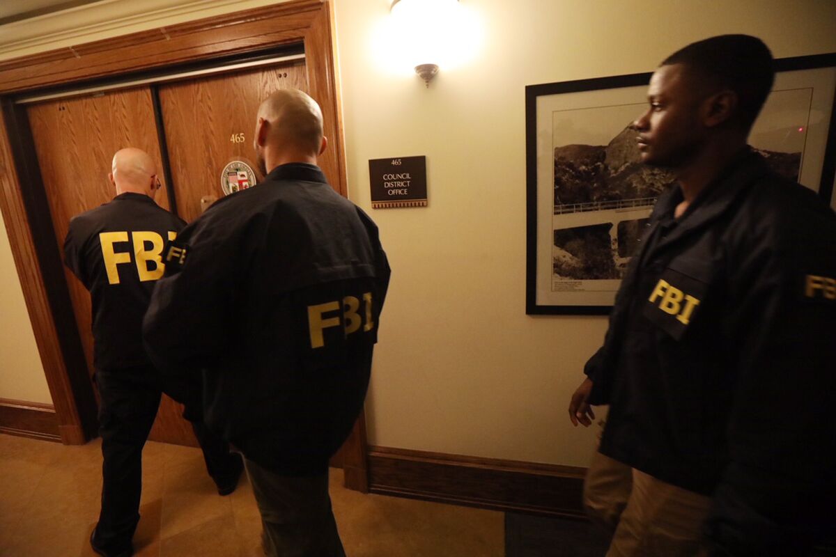 "FBI" 재킷을 입은 사람들이 문에 접근합니다.