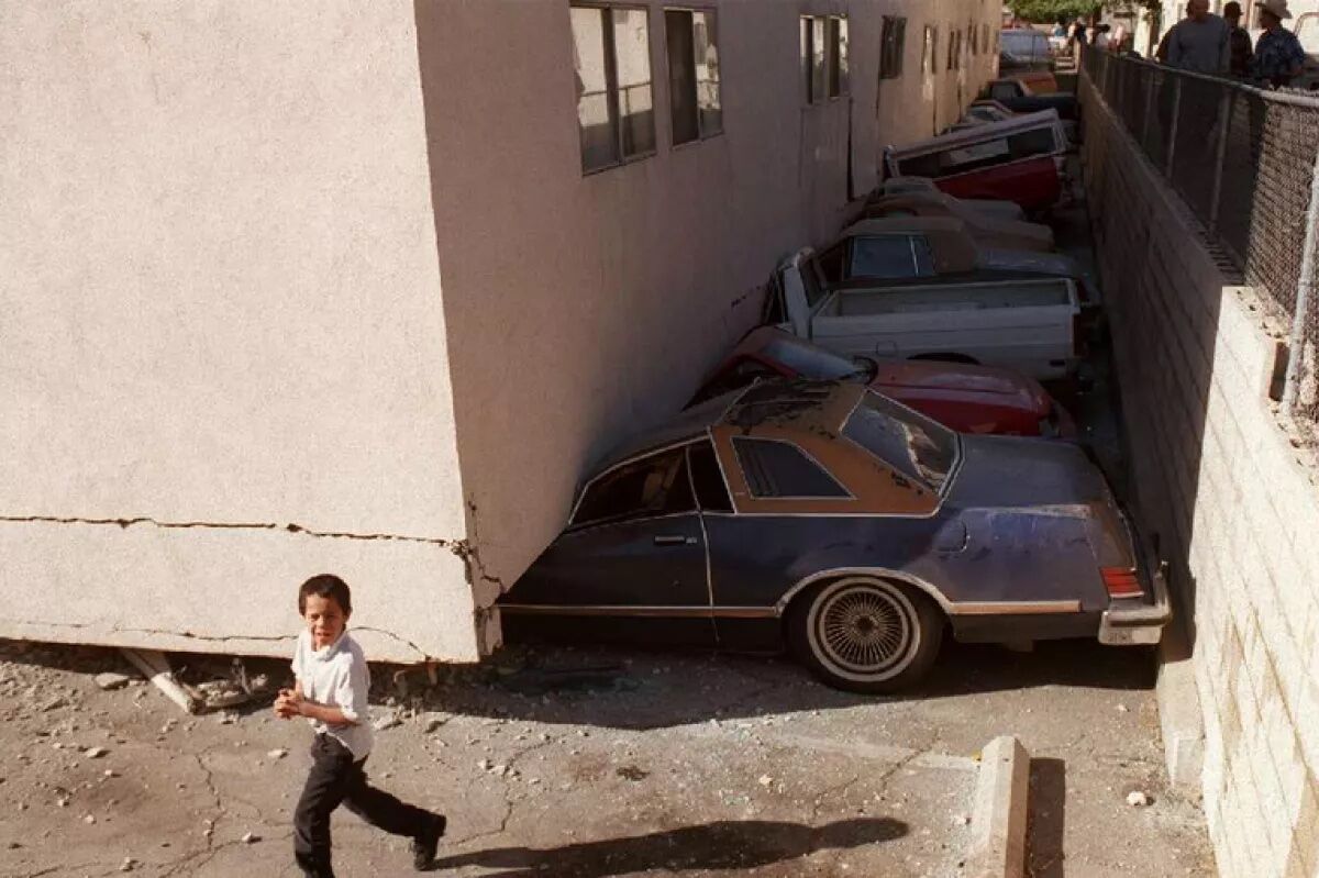 Voertuigen verpletterd toen een flatgebouw met zachte verdiepingen instortte tijdens de aardbeving in Northridge in 1994.