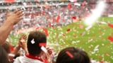 Foto de un hombre aplaudiendo entre la multitud en un estadio de fútbol