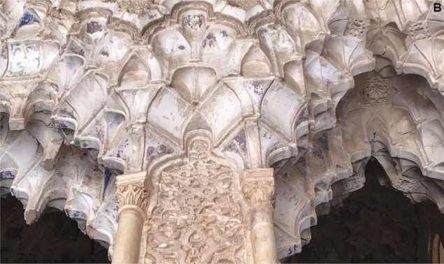 Foto de mocárabes, pequeñas cavidades arqueadas anidadas como un panal de abejas, en la Alhambra, que muestra la decoloración púrpura en la superficie.