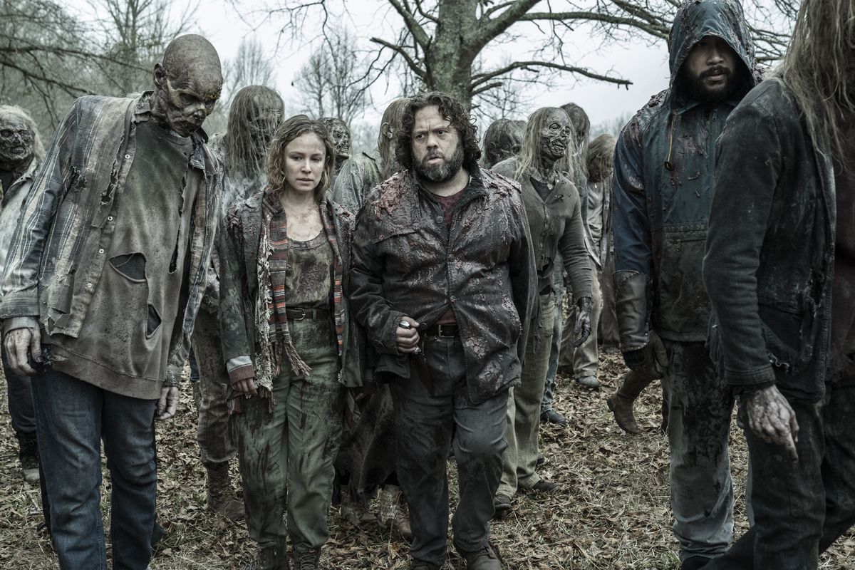 Dan Fogler as Luke, Alex Sgambati as Jules, Cooper Andrews as Jerry walking among a bunch of Walking Dead zombies