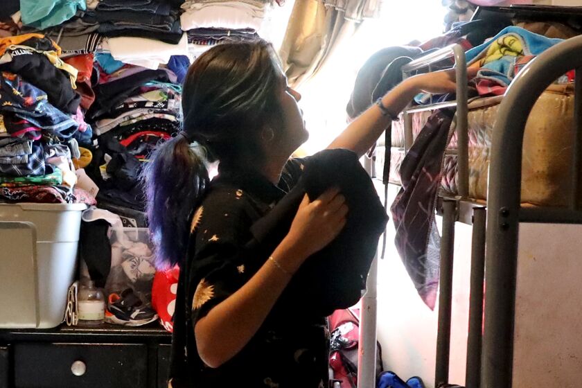 Angie Davila, 20, de oudste van zes kinderen, organiseert haar bezittingen op het bovenste stapelbed in het appartement met één slaapkamer van de familie