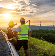 Construction workers observing wind turbines