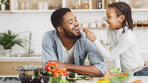Family Happy in Kitchen Eating Fresh Vegetables Healthy Child Smiling