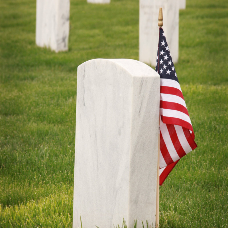 묘비 근처에 서 있는 미국 국기