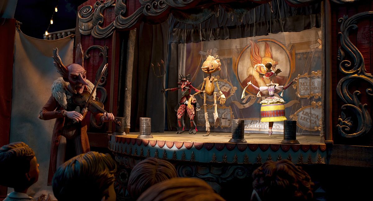 Pinocchio dances on stage with other puppets as Count Volpe plays fiddle