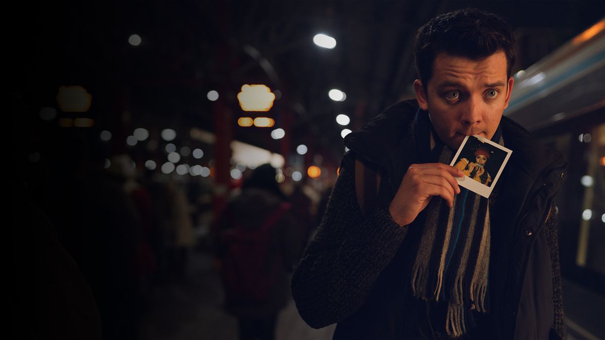 Asa Butterfield holds a photograph in his mouth in Your Christmas or Mine?