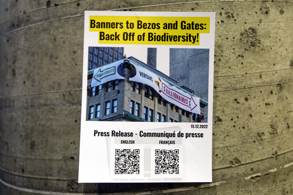 Posters calling for billionaires Jeff Bezos and Bill Gates to “back off” biodiversity finance.