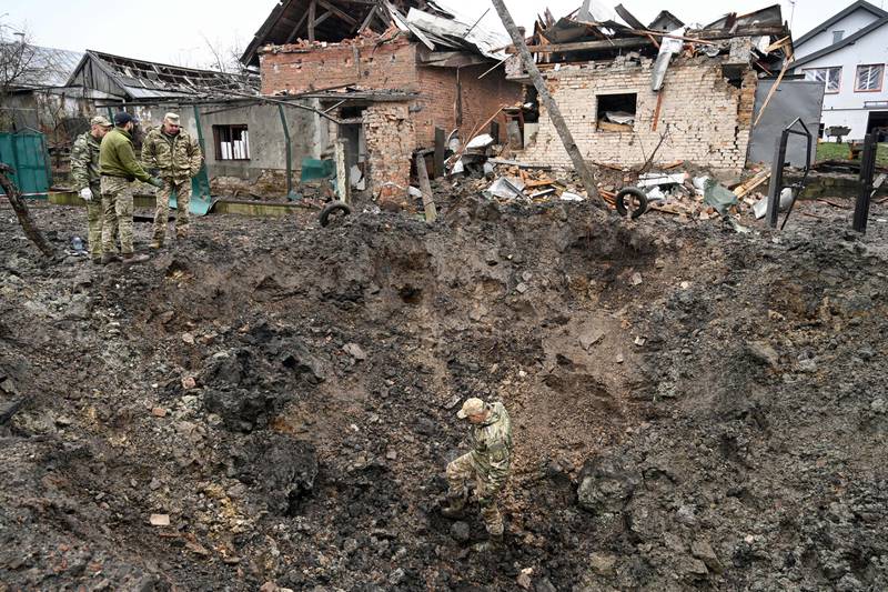 Polis uzmanları, 16 Kasım 2022'de Ukrayna'nın batısındaki Lviv kenti yakınlarındaki bir köye füze saldırısından sonra bir krateri inceliyor.