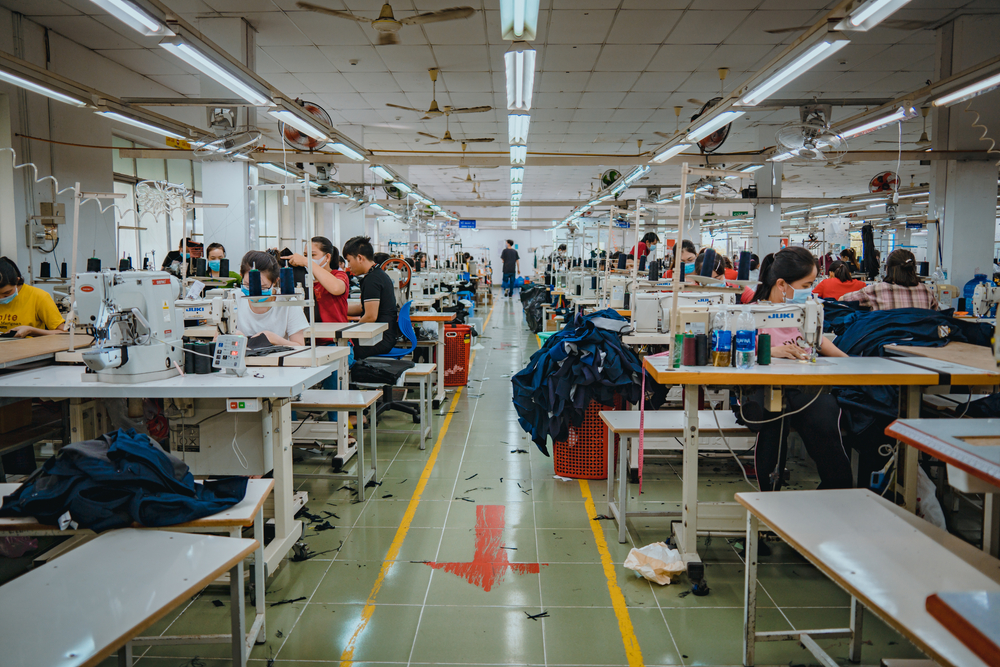 Pekerja pabrik tekstil di mesin jahit