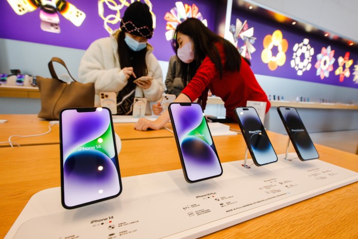 Los clientes miran el teléfono iPhone 14 en una tienda Apple en Beijing, China, en noviembre de 2022