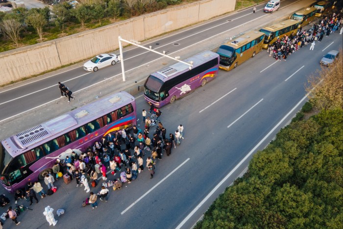 El personal de Foxconn espera para abordar los autobuses de enlace en Zhengzhou, Henan, China, a sus ciudades de origen en octubre de 2022