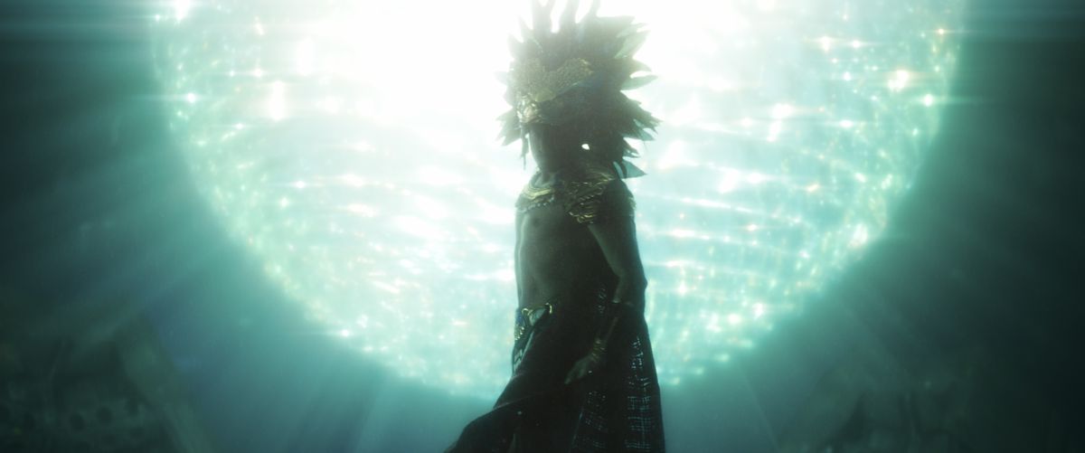 namor onderwater in zwarte panter: wakanda forever, gekleed in traditionele kleding terwijl verlicht door een gloeiende kunstmatige zon