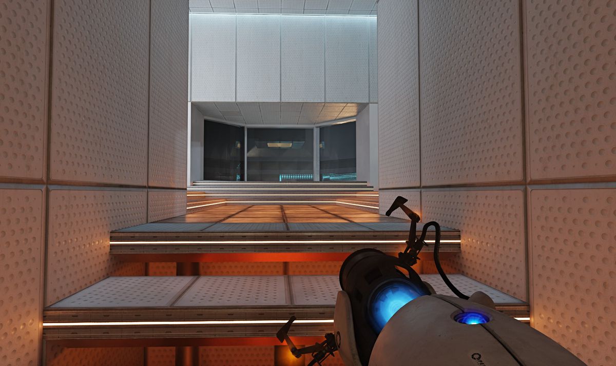 A player walks up a set of stairs in Portal. There’s an orange glow coming from beneath the stairs, which is reflected on the industrial walls encasing the staircase.