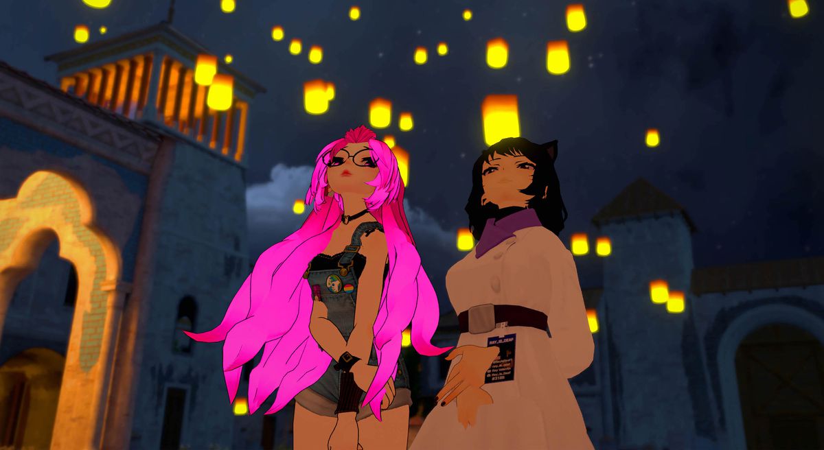 Two VRChat anime-style avatars, a girl with long pink hair and a dark-haired catgirl, watch illuminated lanterns float into the air in We Met In Virtual Reality