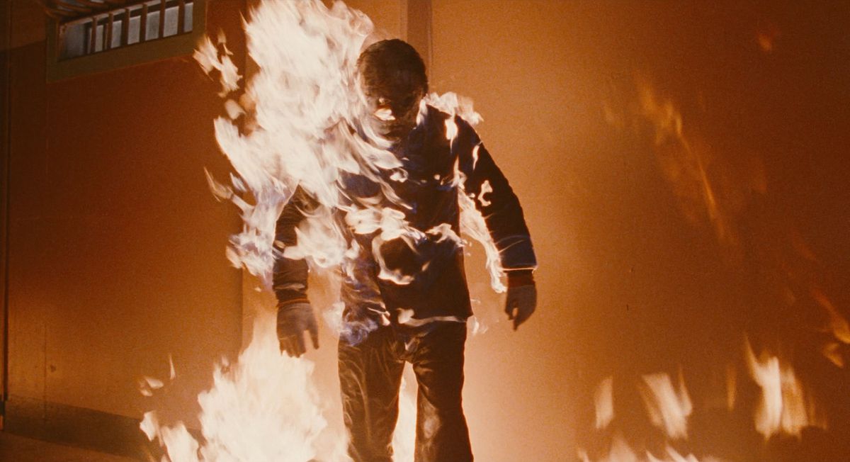 A zombie cop is walking while on fire in Maniac Cop 2.
