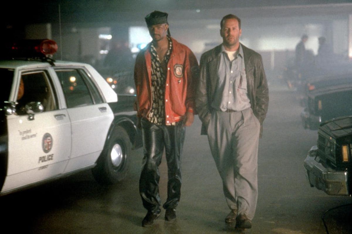 Bruce Willis and Damon Wayans strut past a police car in The Last Boy Scout.
