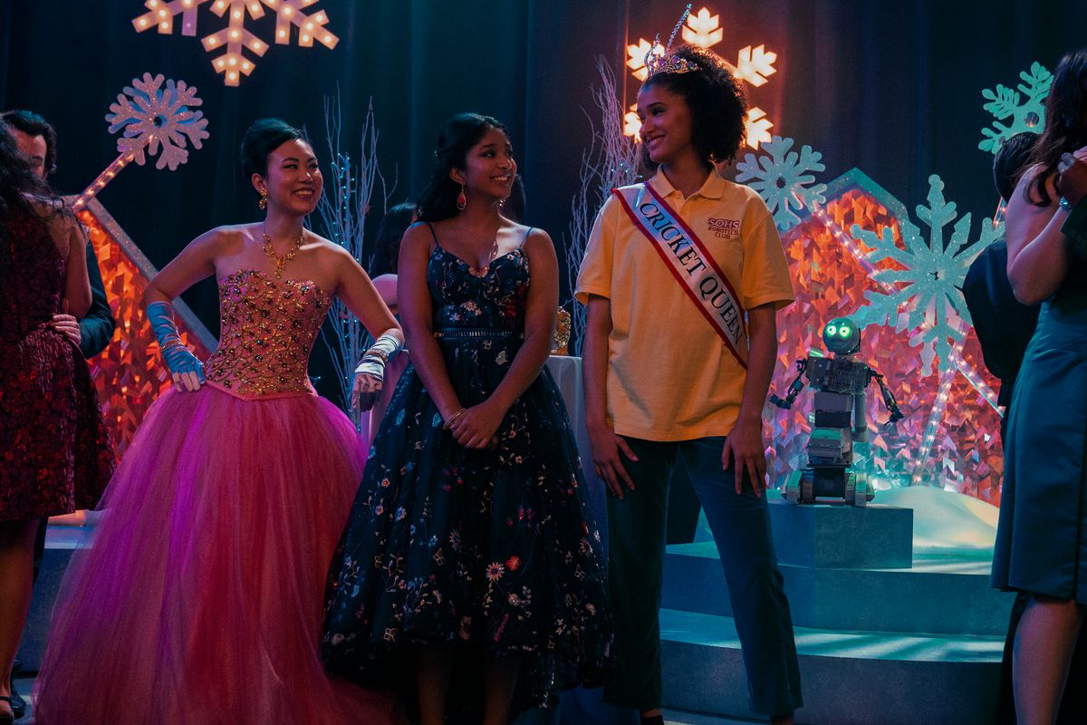 Devi, Eleanor, and Fabiola standing at a dance smiling at each other in a still from Never Have I Ever
