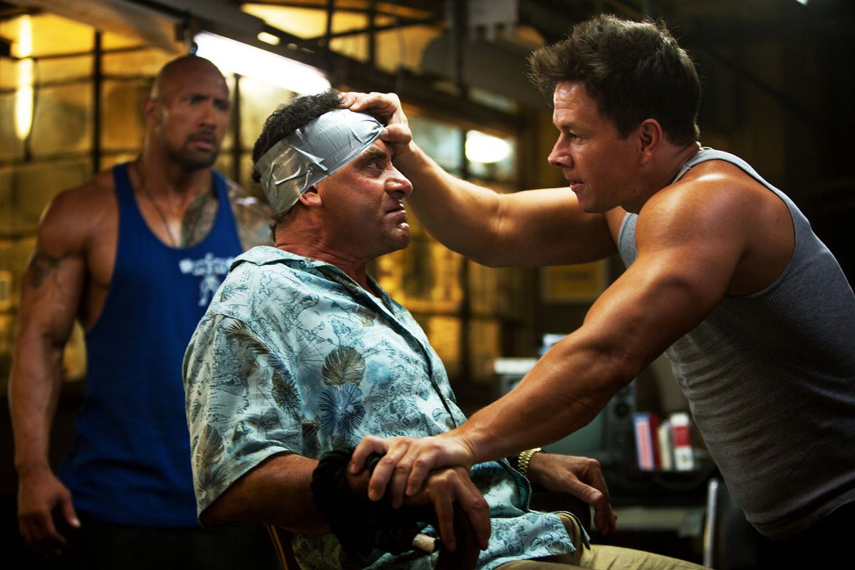 Mark Wahlberg ve Dwayne Johnson, Pain & Gain'de kaçırılan bir Tony Shalhoub'u gözlemliyor.