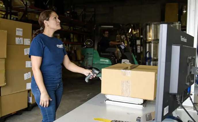 Warehouse Problems - A woman scanning a parcel