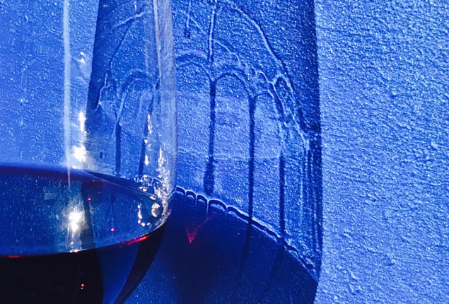 A wine glass and its shadow showing legs or tears on the glass