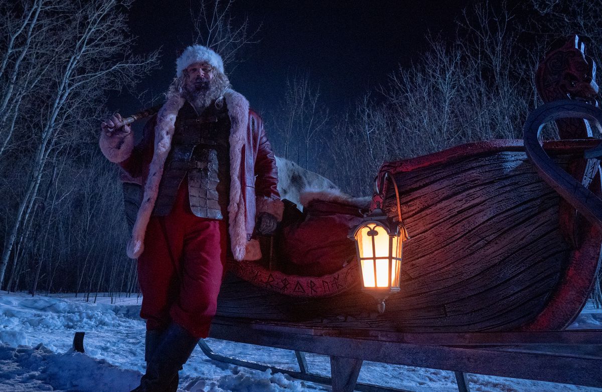 Noel Baba (David Harbour), Şiddetli Gece'de İskandinav rünleriyle oyulmuş kan kırmızısı ahşap tekne şeklindeki bir araç olan kızağına sarhoş bir şekilde yaslanıyor.