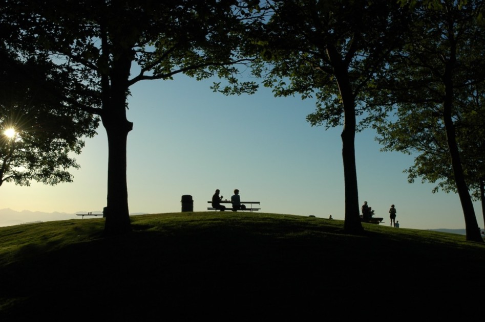 Twee mensen zitten op een picknickbank in Discovery Park, een van de vele parken waar Seattle bekend om staat.