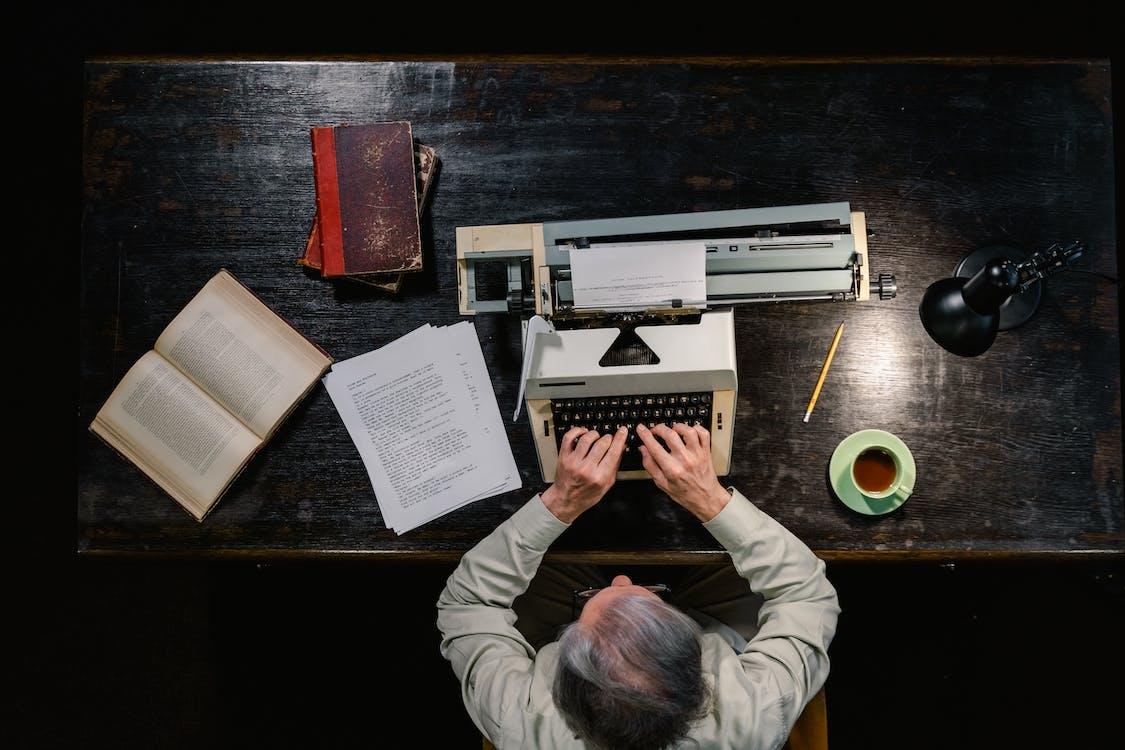 Free A Man Using a Typewriter Stock Photo