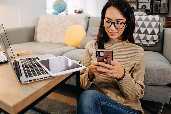 Sử dụng mẹo Slack, một phụ nữ sử dụng cả máy tính xách tay và điện thoại di động của mình để liên lạc từ xa.