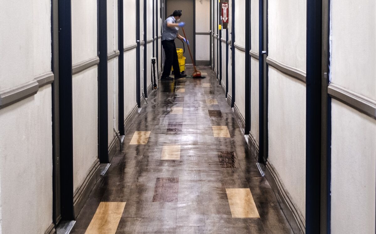 Una persona limpia el pasillo dentro del SRO "Madison Hotel" el viernes 9 de diciembre de 2022 en Los Ángeles.