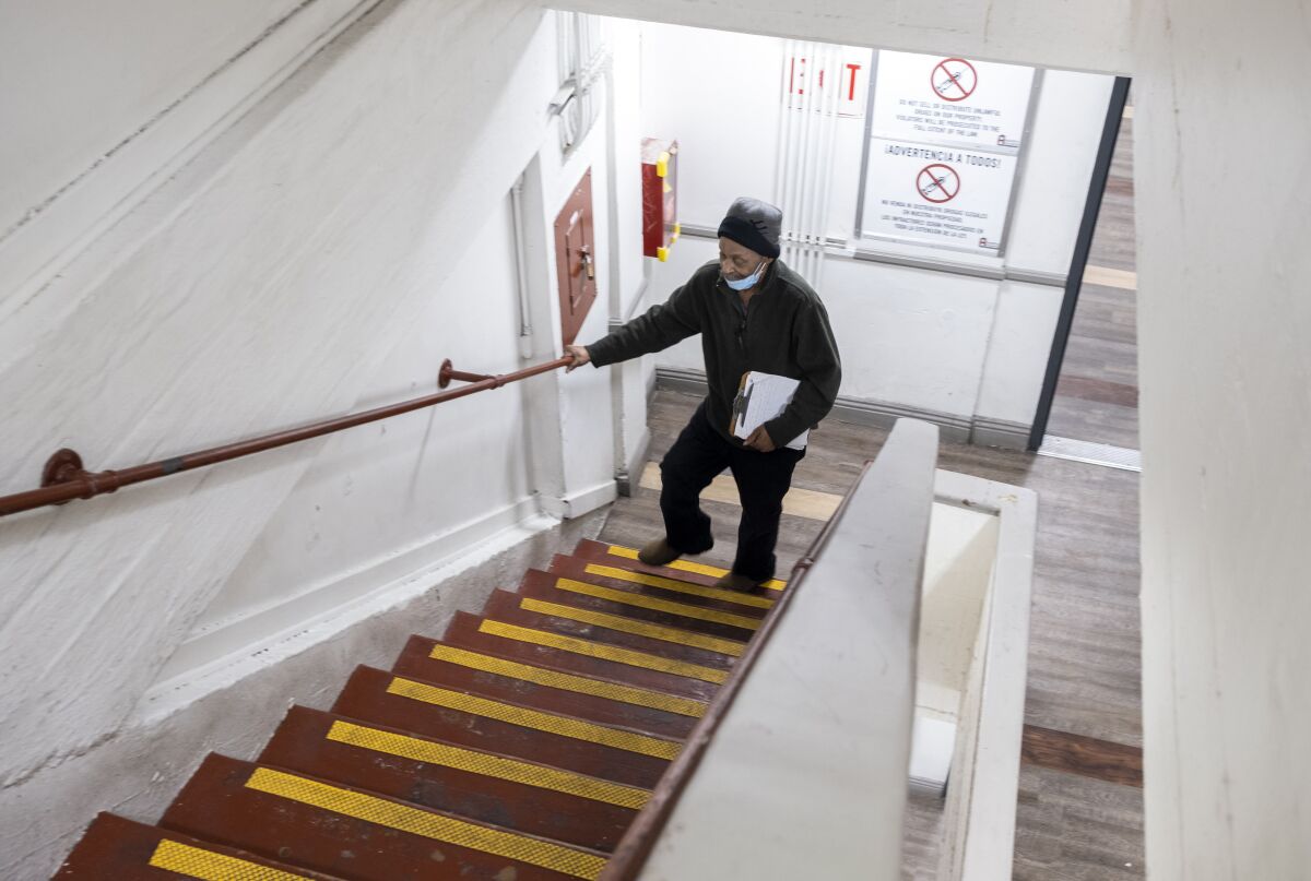 Edwin Linwood, de 71 años, lucha por respirar mientras sube las escaleras del Hotel Madison.