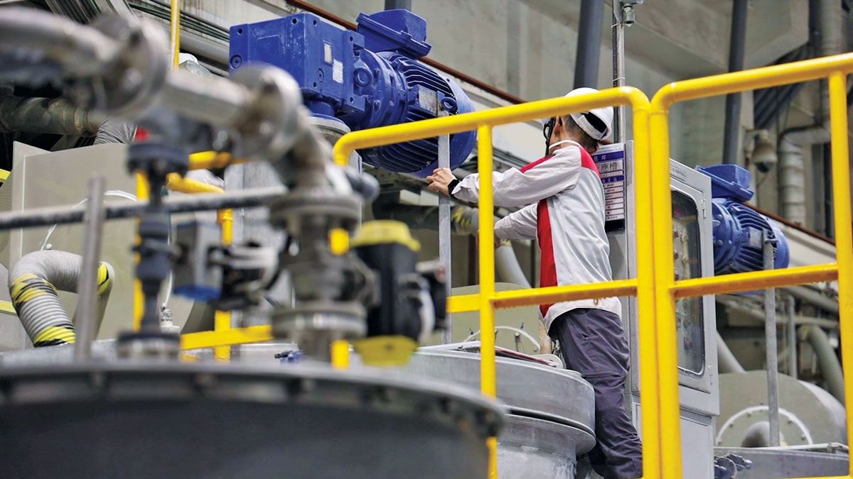 Bir çalışan, lityum demir fosfat üreten bir Aleees fabrikasında makineler üzerinde çalışıyor.