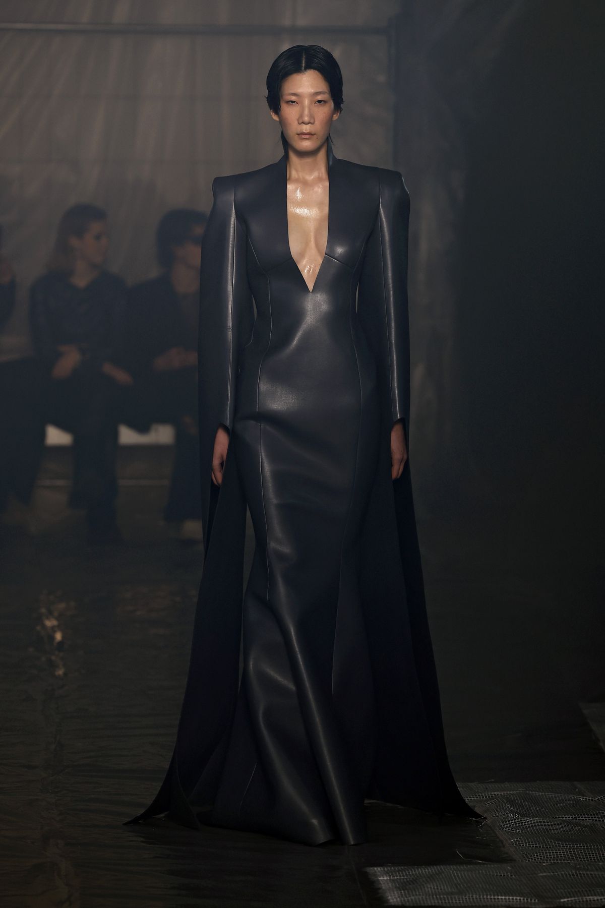 A model wearing a long black leather dress walks the runway at the Han Kjobenhavn fashion show at Milan Fashion Week.