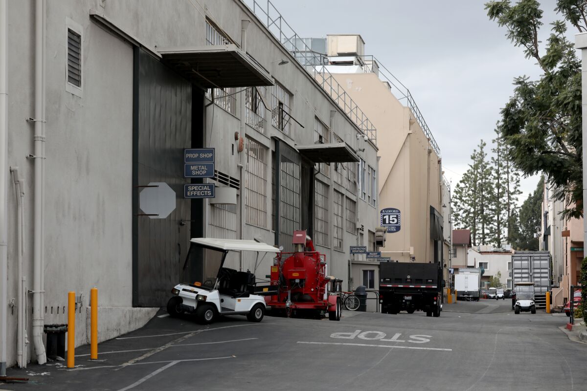 An alley is lined with movie studios of varied architecture.