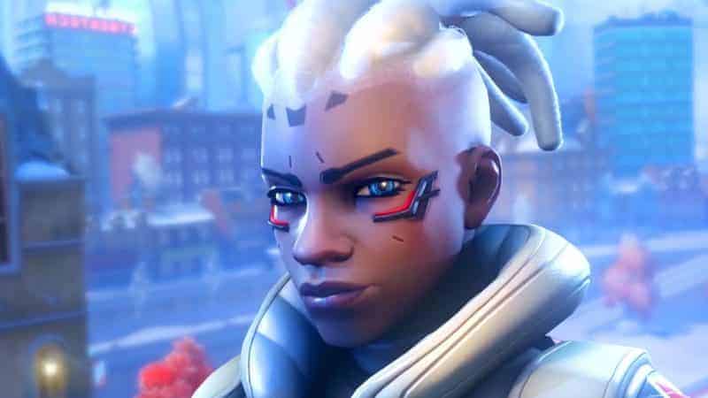 Overwatch 2 hero Sojourn looks at the camera with a serious expression with a futuristic city behind them