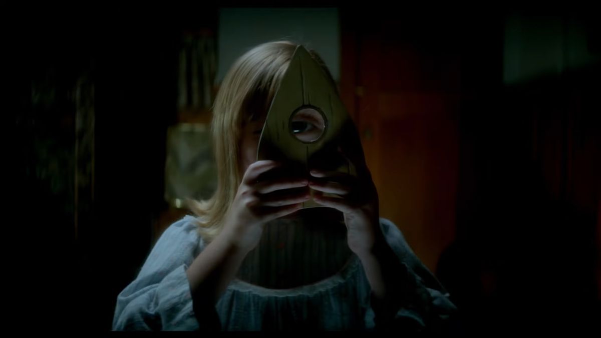 Una niña mira a través de una tabla de ouija en Ouija: Origin of Evil