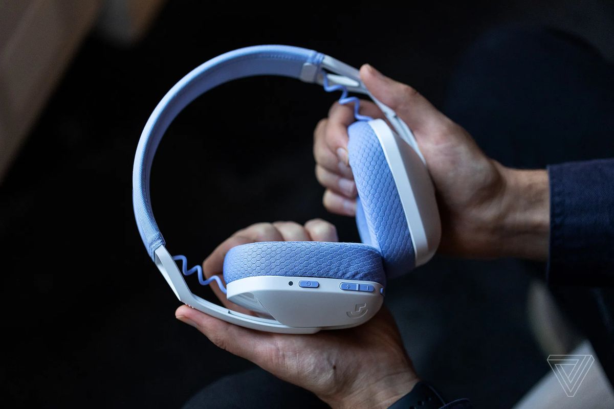 The white and purple Logitech G435 Lightspeed gaming headset sits in the authors hands.