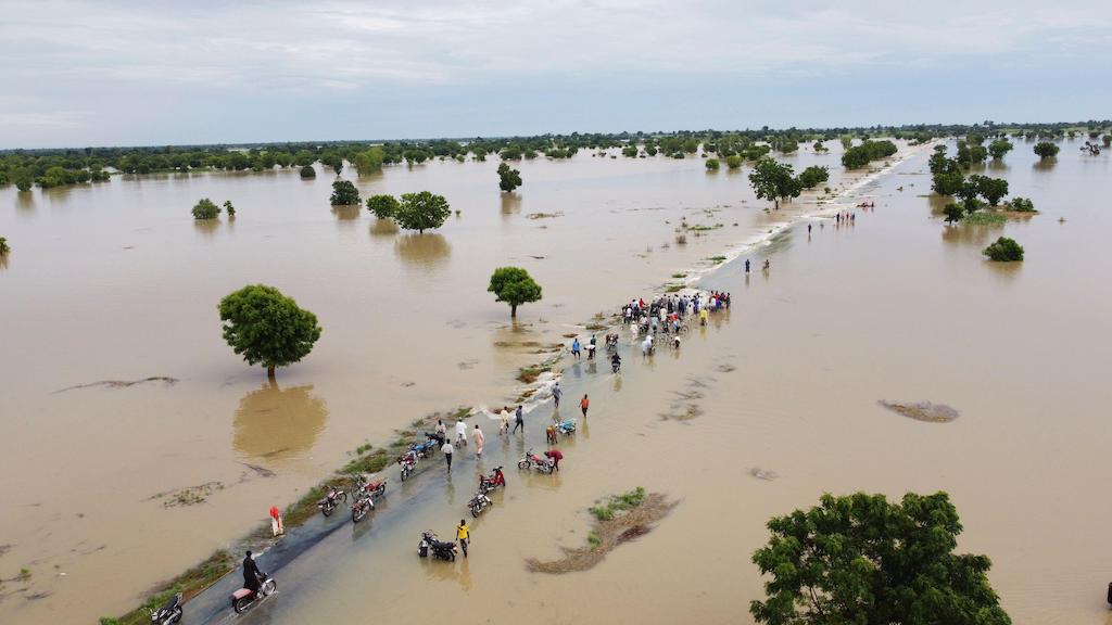 19 年 2022 月 XNUMX 日、ナイジェリアのハデジャで大雨が降った後、洪水の中を歩く人々。