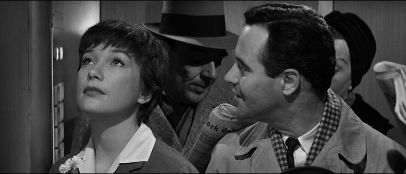 Jack Lemmon mira a Shirley MacLaine en el ascensor de la empresa en The Apartment.