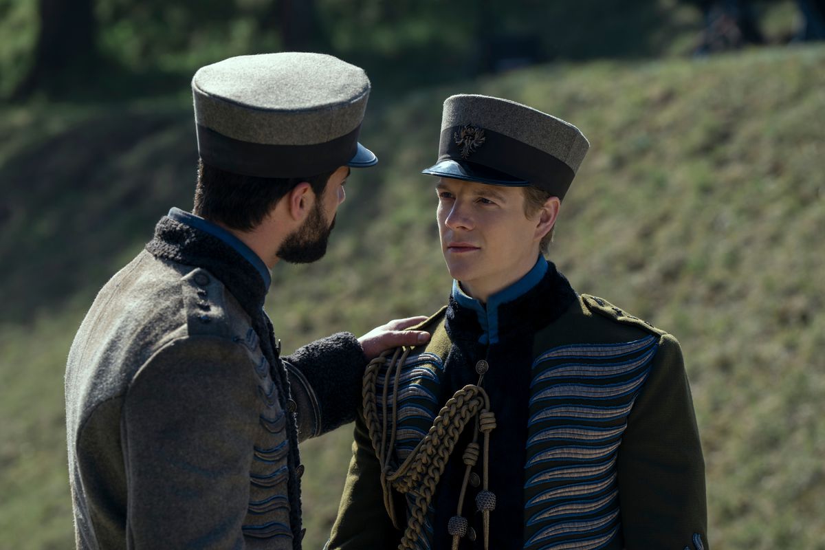 nikolai in his military uniform, getting an encouraging shoulder pat from another uniformed lad