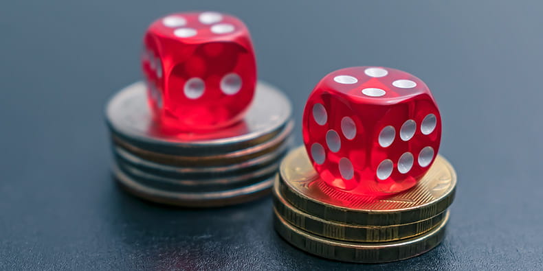 Red Dice on Stacks of Coins