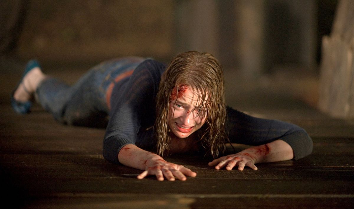 Dana (Kristen Connolly) crawls along a wooden dock, wet and bloodied and terrified, in 2011’s The Cabin in the Woods