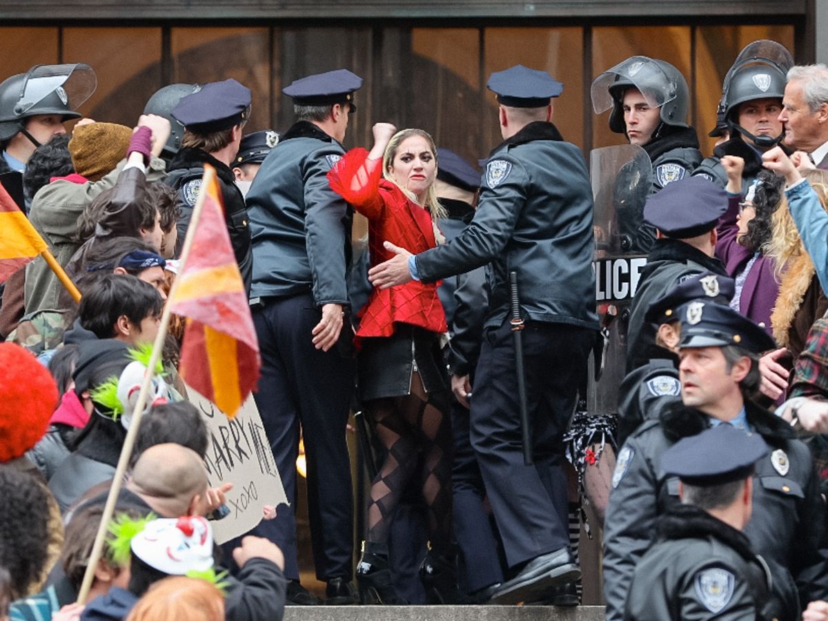 شوهدت ليدي غاغا في مجموعة أفلام 'Joker: Folie a Deux' في 25 مارس 2023 في مدينة نيويورك ، وهي ترفع قبضتها بينما يسحبها رجال شرطة السينما إلى المحكمة ويهتف المتظاهرون باسمها