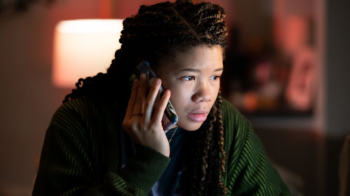 "Kayıp"ta ekran dışında bir ekrana bakarken kulağına cep telefonunu tutan örgülü saçlı genç bir kadın (Storm Reid).
