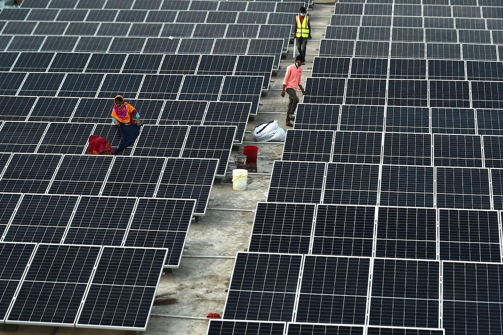 Technicians install solar panels on a factory building in Gazipur on the outskirts of capital Dhaka, Bangladesh on Jan. 3, 2021.
