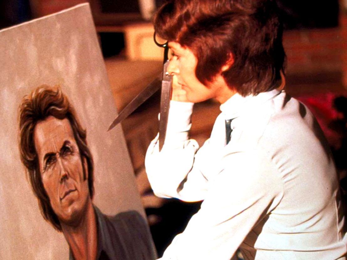 Evelyn (Jessica Walter) tenant une paire de ciseaux contre une toile portrait du disc-jockey Dave (Clint Eastwood) dans Play Misty For Me